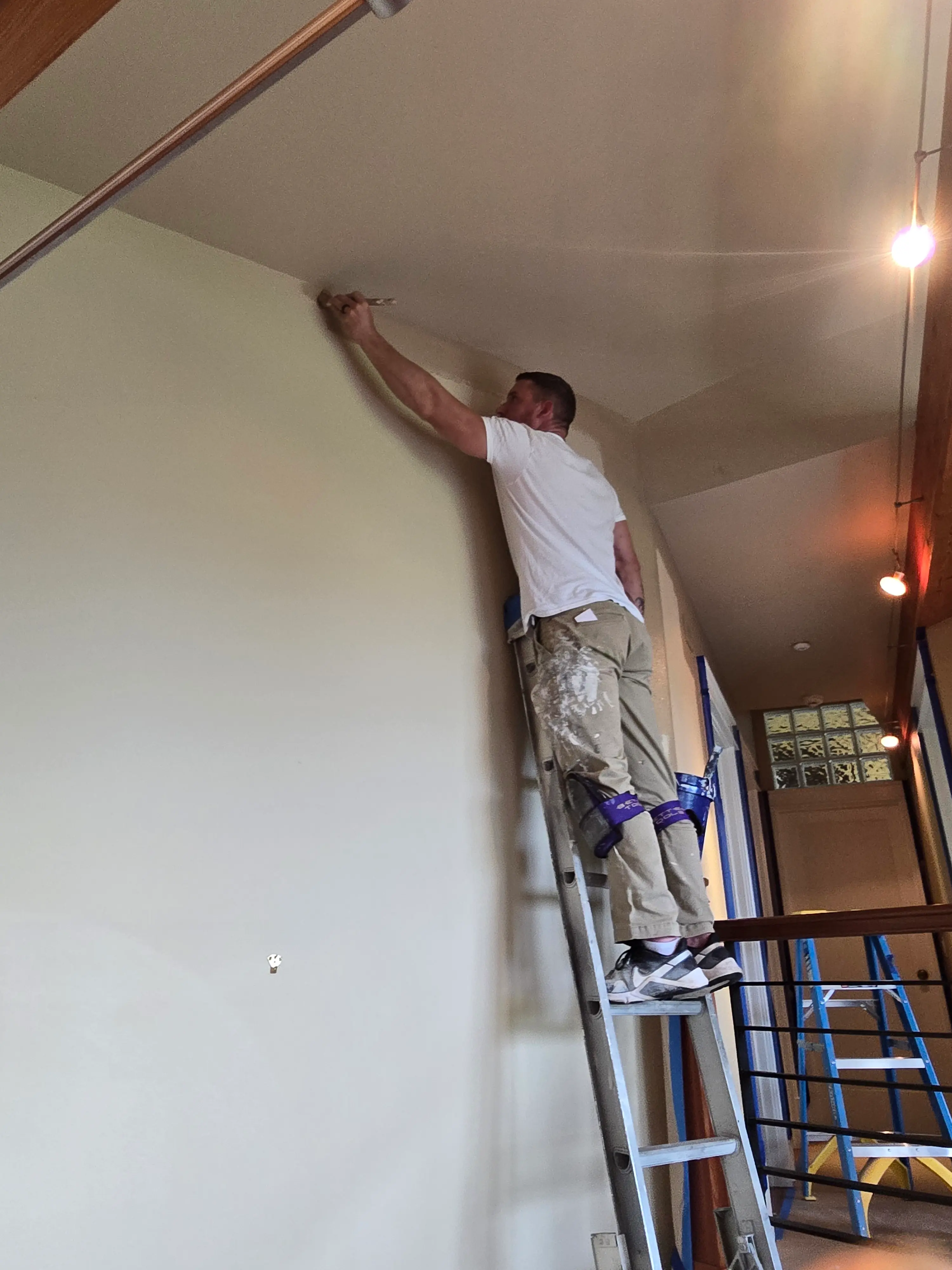 Aaron doing an interior painting job on a ladder